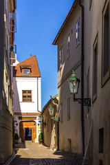 Quiet and cozy street of cobbled stone pavement and the old lanterns . The nineteenth century . The Old Town District . Prague , Czech Republic.
