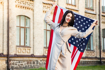 Fototapeta premium Beautiful happy woman with American flag celebrating independence day.