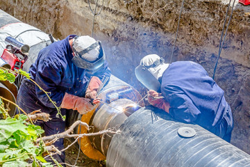 Obraz na płótnie Canvas View on welding team of welders until them assembly a new pipeline