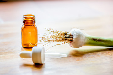 Pipette, medical bottle and organic leek on a wooden table