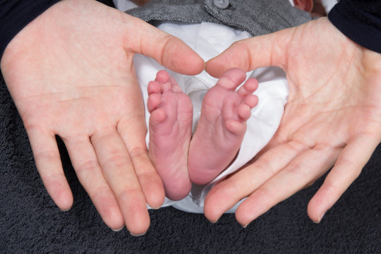 hands mother Shape a Heart with the feet of the newborn baby