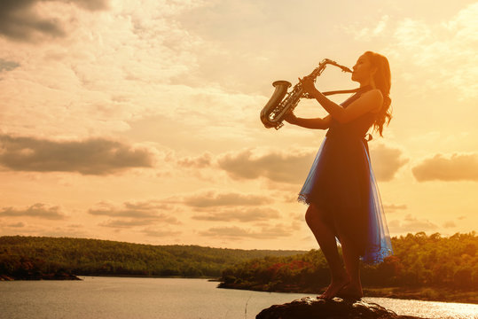 Woman Playing Saxophone Sax At Sunset