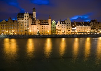 Fototapeta na wymiar Long Embankment and Motlawa River in the Old Town of Gdansk, Poland at night. Mariacka Gate on the left