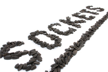 Black fried sunflower seeds on a white background.