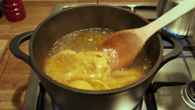 Boiling pasta getting stirred on stove