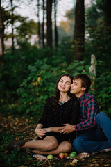 Naklejka premium beautiful couple in a green forest on a picnic brunette happy