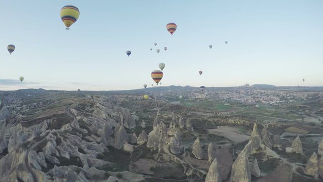 Hot air balloon flying over rock landscape at Cappadocia Turkey. Cappadocia with its valley, ravine, hills, located between the volcanic mountains in Goreme National Park.