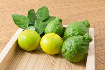 Green Kaffir Lime with Lemon Lime on Wooden Tray