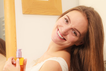 Obraz na płótnie Canvas Woman taking care of her long hair applying cosmetic oil