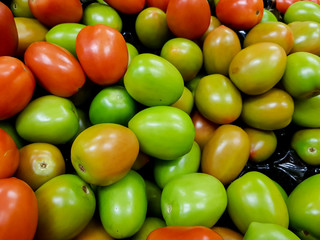 Unripe green tomatoes stacked in a heap