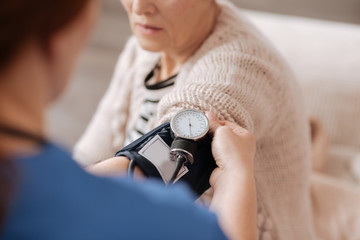 Delicate competent doctor reading ladies blood pressure