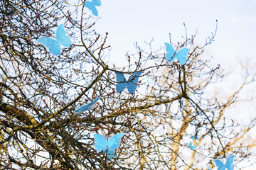 Spring tree and colorful artificial blue butterflies