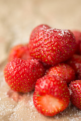 Fresh strawberries with sugar on the wrinkled brown pack paper