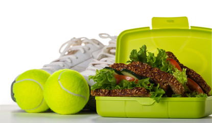 Healthy Life Sport Concept. Sneakers with Tennis Balls, Towel, Apples, Healthy Sandwich and Bottle of Water on Bright Background. Copy Space.