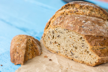 Sliced healthy round black bread on the table with knife