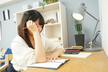 Young woman studying at home	自宅で受験勉強をする若い女性