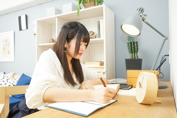 Young woman studying at home	自宅で受験勉強をする若い女性
