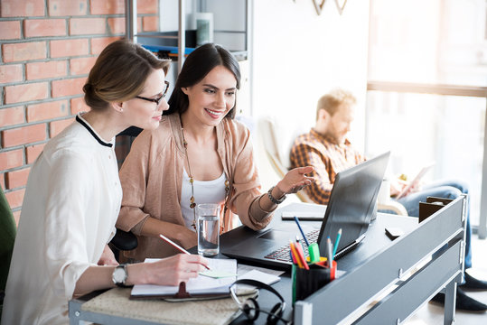 Happy smiling manager sitting beside colleague
