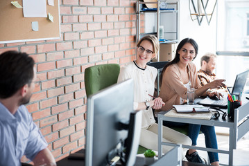 Happy smiling women sitting near desk