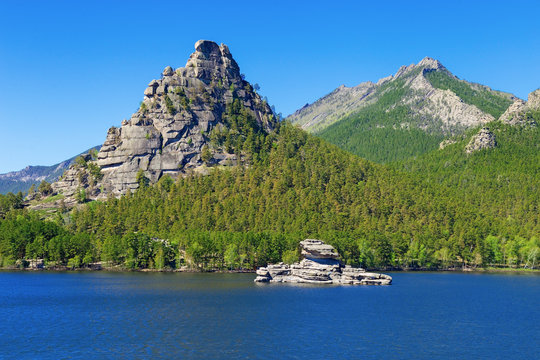 High scaur Okzhetpes and mysterious sphinx Zhumbaktas (puzzle-stone) on Lake Auliekol (Borovoe) are located in Burabay National Nature Park in the Republic of Kazakhstan. Beautiful mountain landscape.