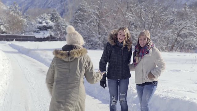 Multiethnic Teen Takes Photo Of Her Happy Friends Enjoying Snow Day In Mountains
