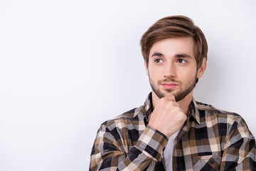 Young bearded handsome student is concentrated on studying. He is in a casual outfit on pure background, thinking