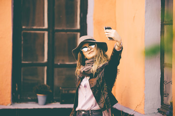 Portrait of a happy woman. Portrait of attractive young girl. Nice girl with sunglasses taking selfie. Woman wearing hat. Vintage girl.