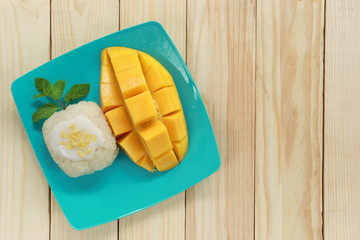 mango and sticky rice on wood background.