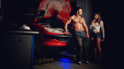 A woman in the garage experiences a sexual attraction to a man with an car mechanic