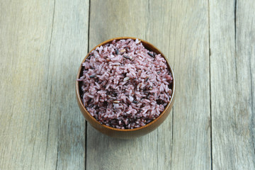Organic Rice berry in wooden dish on wood background.