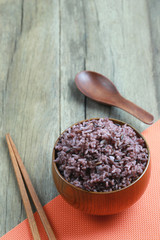 Organic Rice berry in wooden dish on wood background.