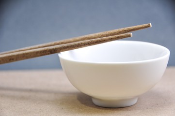 Chopsticks with bowl on grey background