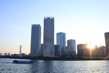 Fototapeta na wymiar 港から見るビル群と夕日