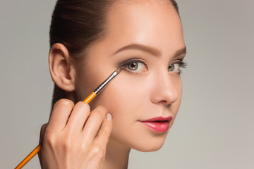 Fototapeta premium Beautiful female eyes with make-up and brush