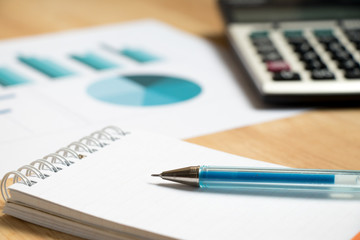 Note paper with pen, graph, calculator background