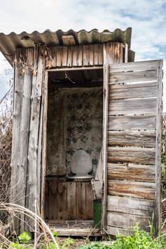 Old wooden rotting toilet in the village