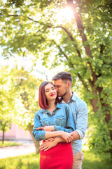 Fototapeta premium Happy young couple at park standing and laughing on the bright sunny day