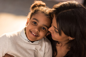 Fototapeta premium portrait of smiling mother hugging happy little daughter