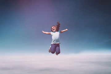 Little girl jumping on blue sky