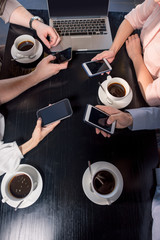 Fototapeta na wymiar cropped shot of business team on meeting with smartphones in cafe, business lunch concept