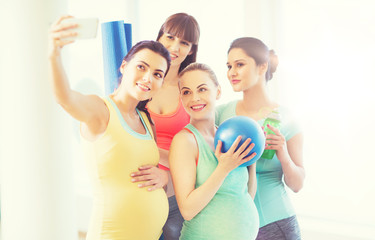 pregnant women taking selfie by smartphone in gym