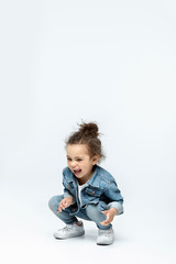 funny little kid girl in jeans isolated on white