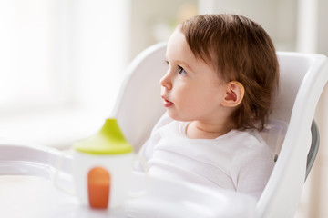 happy baby girl sitting in highchair at home