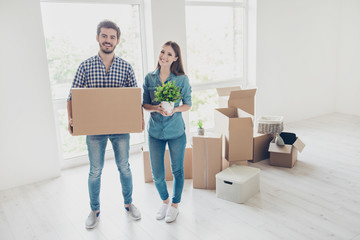Fototapeta na wymiar New life, new start, new home for a young family. What a joy! Happy cheerful lovers are unpacking in a new apartment, standing in a casual wear