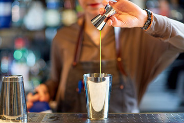 Fototapeta na wymiar bartender with cocktail shaker and jigger at bar
