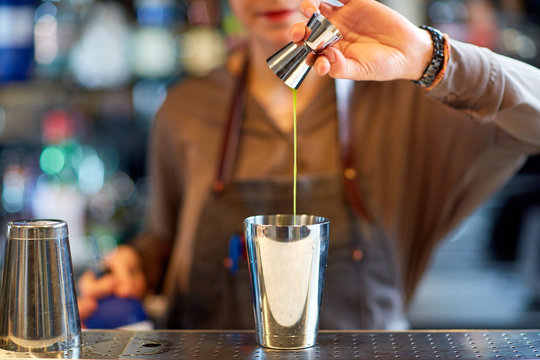 Bartender With Cocktail Shaker And Jigger At Bar