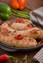 Grilled sausages in frying pan. Wooden background. Top view. Close-up