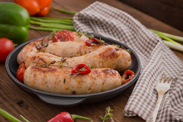 Grilled sausages in frying pan. Wooden background. Top view. Close-up