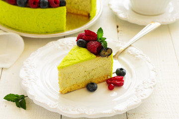 Home pistachio cheesecake with raspberries and blueberries.