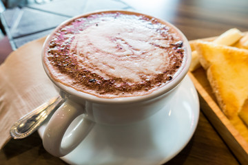 Hot chocolate in white cup on wooden table